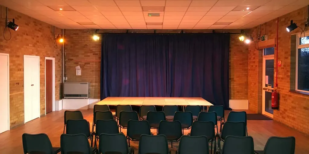 Inside St Saviour's church hall, with the stage at the far end